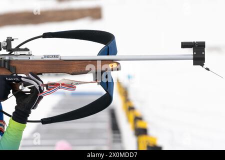 Sportlerbiathletin-Gewehrschießen im Stehen. Biathlet im Schießbereich. Selektiver Fokus, extreme Nahaufnahme. Offener Jugendbiathlon-Wettkampf Stockfoto