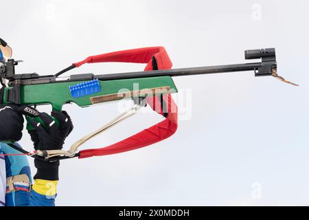 Sportlerbiathletin-Gewehrschießen im Stehen. Selektiver Fokus, extreme Nahaufnahme. Biathlet im Schießstand. Offene Jugendbiathlon-Wettkämpfe Stockfoto