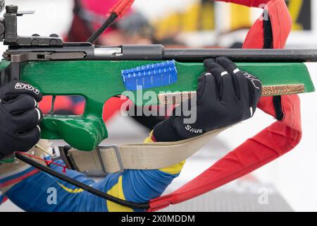 Sportlerbiathletin-Gewehrschießen in Bauchlage. Selektiver Fokus, extreme Nahaufnahme. Biathlet im Schießstand der Open Youth Biathlon Compe Stockfoto