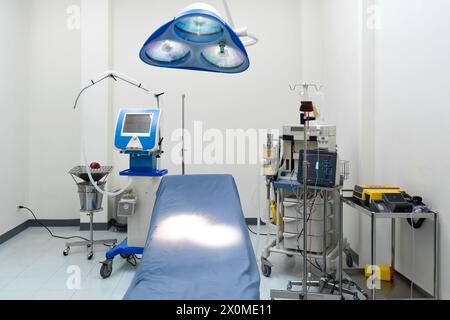Ein typischer Operationssaal in einem Krankenhaus mit Operationslicht über dem Kopf, um das chirurgische Team während des Eingriffs hell und gerichtlich zu beleuchten. Stockfoto
