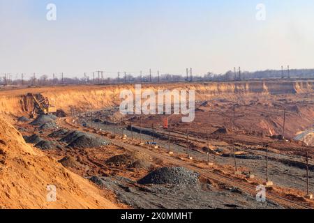 Großer gelber Bagger, der im Eisenerzsteinbruch arbeitet Stockfoto