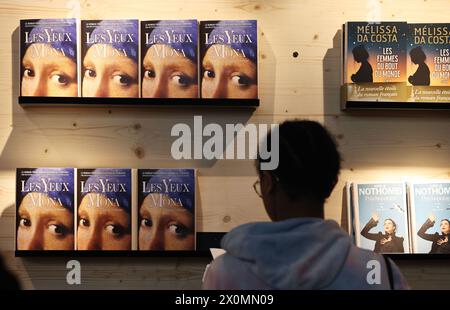 Paris, Frankreich. April 2024. Ein Besucher liest ein Buch auf dem Pariser Buchfestival 2024 in Paris, Frankreich, 12. April 2024. Das Buchfestival wurde am Freitag eröffnet und dauert drei Tage hier. Quelle: Gao Jing/Xinhua/Alamy Live News Stockfoto