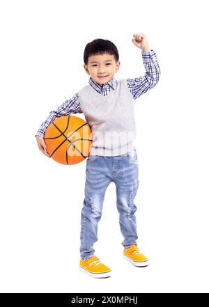 Glücklicher asiatischer Junge, der einen Basketball auf weißem Hintergrund hält Stockfoto