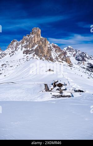 Aus der Vogelperspektive auf dem schneebedeckten Giau-Pass mit dem Hotel Passo Giau im Winter, dem Gipfel des Ra Gusela in der Ferne. Stockfoto