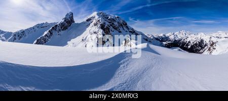 Schneetreiben schafft kunstvolle Strukturen rund um den Giau Pass im Winter, schneebedeckte Gipfel des Torre Dusso, Mt. Cernera und Marmolada in der Ferne. Stockfoto