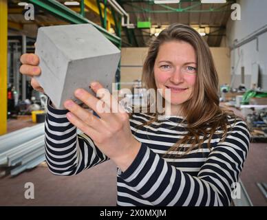 Cottbus, Deutschland. April 2024. Nora Baum, autorisierte Unterzeichnerin der Sonocrete GmbH, hält einen Betonwürfel in den Händen. Das Unternehmen beschäftigt derzeit 21 Mitarbeiter und wurde 2018 gegründet. Durch den Einsatz von Hochleistungs-Ultraschall härtet Beton, der mit Hilfe von Sonocrete hergestellt wird, schneller aus. Dies bedeutet, dass weniger umweltschädlicher Zement benötigt wird. Die Sonocrete GmbH wurde 2023 mit dem Brandenburgischen Innovationspreis ausgezeichnet. Quelle: Patrick Pleul/dpa/Alamy Live News Stockfoto