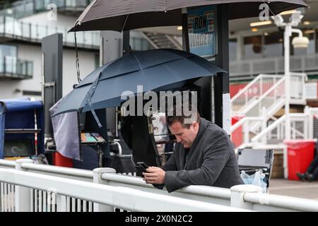 Liverpool, Großbritannien. April 2024. Ein Buchmacher überprüft sein Handy, bevor er während des Randox Grand National Day 2024 auf der Aintree Racecourse, Liverpool, Vereinigtes Königreich, am 13. April 2024 (Foto: Mark Cosgrove/News Images) in Liverpool, Vereinigtes Königreich, am 13. April 2024 ankommt. (Foto: Mark Cosgrove/News Images/SIPA USA) Credit: SIPA USA/Alamy Live News Stockfoto