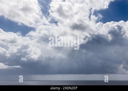 Ein dramatischer Blick auf die Meereslandschaft von Ibiza unter einem dynamischen Himmel, wo Wolken auf einen drohenden Sturm über dem ruhigen Mittelmeer hinweisen Stockfoto