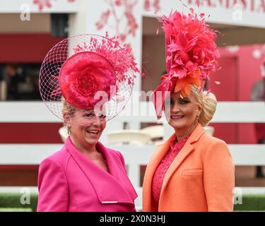 Liverpool, Großbritannien. April 2024. Zwei Damen kommen mit rosa und orangen Kleidern und Hüten während des Randox Grand National Day 2024 auf der Aintree Racecourse, Liverpool, Vereinigtes Königreich, am 13. April 2024 (Foto: Mark Cosgrove/News Images) in Liverpool, Vereinigtes Königreich am 13. April 2024. (Foto: Mark Cosgrove/News Images/SIPA USA) Credit: SIPA USA/Alamy Live News Stockfoto