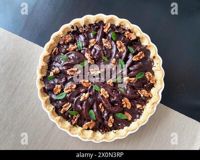 Hausgemachte Torte mit Birne und dunkler Schokolade in einer weißen Auflaufform, natürliches Licht. Stockfoto