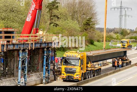 Owschlag, Deutschland. April 2024. Auf einer Baustelle an der Autobahn A7 zwischen den Anschlussstellen Owschlag und Rendsburg/Büdelsdorf werden vorgefertigte Brückenbauteile in Position gebracht. Die Fahrbahn in Richtung Hamburg wird vom 12. April 2024 von 20 Uhr bis 15. April 2024 um 5 Uhr gesperrt. Die Träger werden zunächst auf Tiefladern auf die Baustelle geliefert und dann mit einem 500-Tonnen-Kran in Position gebracht. Quelle: Axel Heimken/dpa/Alamy Live News Stockfoto