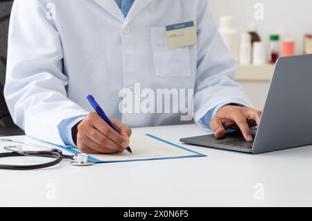 Nahaufnahme eines Arztes mit Computer und Notizen in einer Praxis im Krankenhaus Stockfoto