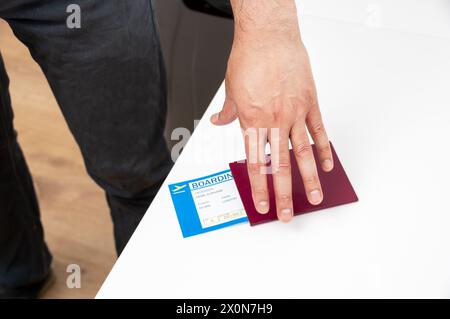 Nicht erkennbare Person, die zu Hause eine Bordkarte der Fluggesellschaft vorhält Stockfoto