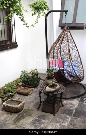 Casa Encantada . Außenansicht eines kleinen, intimen Boutique-Hotels in Antigua - Calle Poniente. Guatemala, Zentralamerika. Schaukelstuhl in einem Innenhof. Stockfoto