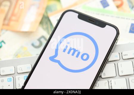 KIEW, UKRAINE - 1. APRIL 2024 IMO-Messenger-Symbol auf dem Smartphone auf vielen Euro-Geldscheinen. IPhone-Display mit App-Logo mit Euro-Banknoten in europäischer Währung und weißer Tastatur Stockfoto