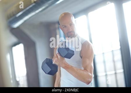 Mann, Gewichtheben und Porträt im Fitnessstudio für Fitness mit Hantel, Workout Herausforderung und starke Muskeln. Bodybuilder, Profisportler und Krafttraining Stockfoto