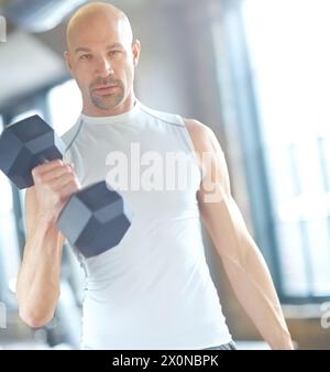 Mann, Gewichtheben und Sport im Fitnessstudio mit Porträt für Kurzhanteltraining, Fitness-Herausforderung und starke Muskeln. Bodybuilder, Profisportler und Kraft Stockfoto