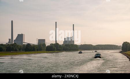Blick stromaufwärts des Rheins mit Schiffen und dem Dampfkraftwerk in Karlsruhe, Baden-Württemberg, Deutschland Stockfoto