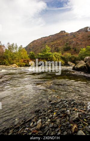 Berggipfel, der über dem schnell fließenden Aflon Glaslyn im Eryri-Nationalpark in Wales aufsteigt Stockfoto