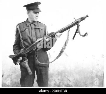 DIE BRITISCHE ARMEE IM TUNESISCHEN FELDZUG, NOVEMBER 1942–MAI 1943 – Ein britischer Soldat untersucht ein gefangenes deutscher MG 42 Maschinengewehr, wahrscheinlich in Ain Tunga, 3. Januar 1943 britische Armee, britische Armee, 1. Armee Stockfoto