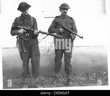 DIE BRITISCHE ARMEE IM TUNESISCHEN FELDZUG, NOVEMBER 1942-MAI 1943 - RegimentsSergeant Major Timbrell und Sergeant C. Stewart vom 2. Bataillon, Coldstream Guards mit einem deutschen MG 34 Maschinengewehr und einem MP40 Maschinengewehr, das von einer deutschen Einheit von 30 Soldaten auf einem Bauernhof in der Nähe von Medjez el Bab am 25. Dezember 1942 gefangen wurde. Ein deutscher Soldat wurde getötet und drei verletzt. Die Operationen in Tunesien fanden weiterhin in geringem Umfang statt, und die britische First Army war hauptsächlich auf Patrouillenaktivitäten ausgerichtet. Auch schlechtes Wetter wurde in dieser Zeit erlebt und Schlamm behinderte die großräumige Bewegung der schweren Fahrzeuge Britis Stockfoto