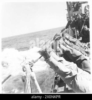 Australische Truppen reisen von Tobruk aus an Bord eines Zerstörers und ruhen während der Reise auf der Schiene aus. Stockfoto