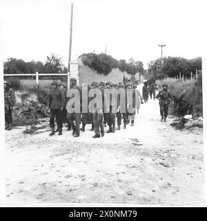 D-DAY - BRITISCHE TRUPPEN WÄHREND DER INVASION DER NORMANDIE am 6. JUNI 1944 marschierten deutsche Kriegsgefangene entlang der Rue du Four-à-Chaux in Ranville von Truppen der 6. Luftlandedivision am 6. Juni 1944 Stockfoto