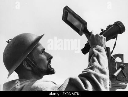 Ein BESUCH AUF EINEM FLUGABWEHRSCHIFF, ENGLAND, 1940 - der Anti-Aircraft Control Spotter auf diesem Flugabwehrschiff blickt durch ein dunkles Glas für feindliche Flugzeuge in die Sonne, England, 1940 Stockfoto