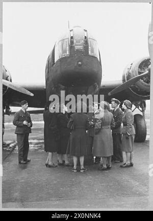 Foto, das weibliche Arbeiter einer Royal Ordnance Factory zeigt, die eine Bomberkommando der Royal Air Force besuchen und eine Erklärung über die Details eines Bombers aus Wellington erhalten. Stockfoto