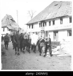 JUGOSLAWIEN: DEUTSCHE BATTERIE AUS DEM HINTERHALT - Partisanen beider Geschlechter aus 10 BDE, 29 Division, 2 Korps, marschieren durch das Dorf Kiseoak, N. von Sarajevo, um die zurückziehenden Deutschen zu verfolgen. Fotografisches negativ, britische Armee Stockfoto