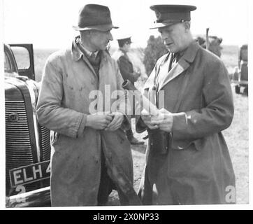 LORD GORT INSPIZIERT EINEN ARTILLERIEBEREICH - Ein Bauer zeigt Lord Gort eine deutsche Brandbombe, die auf sein Land gefallen war. Fotografisches negativ, britische Armee Stockfoto