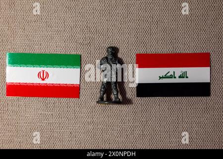 Eine Soldatenfigur auf dem Hintergrund der Flaggen des Iran und des Irak Stockfoto