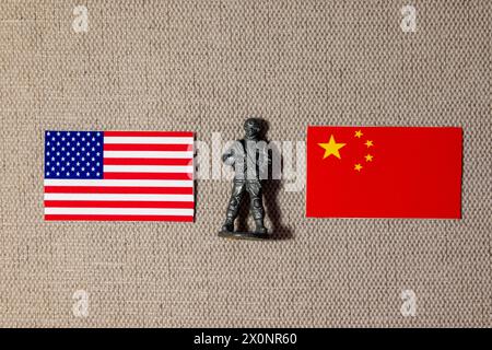 Eine Soldatenfigur auf dem Hintergrund der Fahnen der USA und Chinas Stockfoto