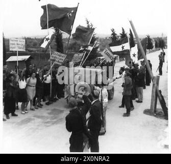 Partisanen, die Banner tragen, treffen auf gepanzerte Wagen der 12 Lancer nahe dem Fluss Izonso jenseits von Pieris während des Vormarsches in Richtung Triest. Stockfoto