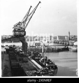 Fotografisches negativ mit Panoramablick auf den Hafen von Dieppe mit königlichen Ingenieuren der 2. Armee, die Läden und Vorräte für britische Streitkräfte, 21. Armeegruppe, verladen. Stockfoto