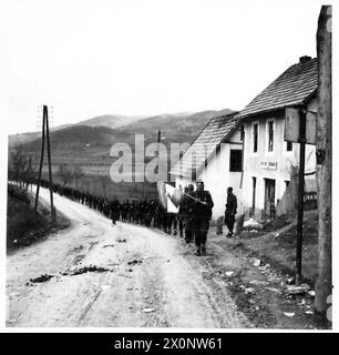 JUGOSLAWIEN: DEUTSCHE BATTERIE AUS DEM HINTERHALT - Partisanen beider Geschlechter aus 10 BDE, 29 Division, 2 Korps, marschieren durch das Dorf Kiseoak, N. von Sarajevo, um die zurückziehenden Deutschen zu verfolgen. Fotografisches negativ, britische Armee Stockfoto