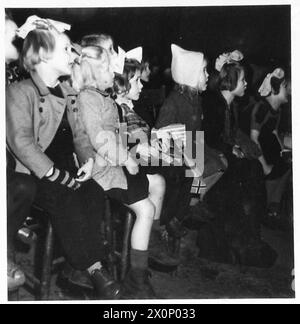 TRUPPENFEIER FÜR NIEDERLÄNDISCHE KINDER - die Kinder, die die Filmshow sehen. Fotografisches negativ, britische Armee, 21. Armeegruppe Stockfoto