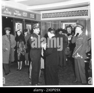 ERSTE NACHT DES „BURMA VICTORY“ IM WARNER THEATRE, LONDON - Lieutenant Colonel Asher, Produzent von M. G.M., Ankunft mit Lieutenant Colonel David Macdonald, dem Produzenten und seiner Frau im Hintergrund. Fotografisches negativ, britische Armee Stockfoto