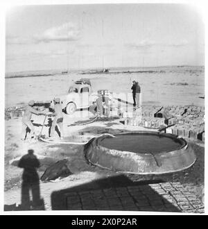 Ein WASSERPUNKT IN DER westlichen WÜSTE - die Bilder zeigen zwei indische Soldaten an der Pumpe, die Dosen mit Wasser aus einem der Leinentanks füllen. Die Tanks ähneln denen, die für die Brandbekämpfung in England verwendet werden. Fotografisches negativ, britische Armee Stockfoto