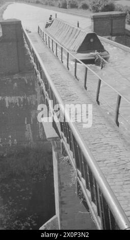 BRITISH CANALS IN WARTIME: TRANSPORT IN BRITAIN, 1944 - Ein Blick auf das Aquädukt, das den Grand Union Canal über den Fluss Nene bei Wolverton in Buckinghamshire führt. Wenn Sie bei Sonnenschein über das Aquädukt fahren, können Sie den „Butty“ eines Paares von Kanalbooten sehen. Kanalboote werden meist paarweise betrieben, der Anführer wird von einem Motor betrieben, der zweite, der Butty, wird hinter ihm gezogen Stockfoto