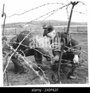 MIT DER SCHWARZEN UHR AUF DEN SHETLAND-INSELN - Men of the Black Watch, die Stacheldrahtverstrickungen errichtet. Fotografisches negativ, britische Armee Stockfoto