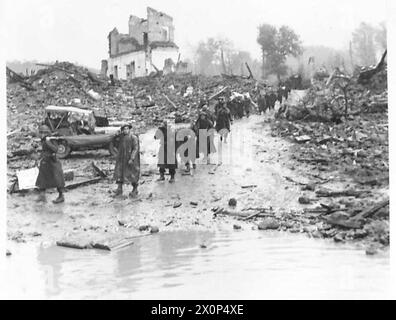 ITALIEN: FÜNFTER ARMYTHE ANGRIFF AUF DEN MOUNT CAMINO - Eine Linie von Bahrern marschiert durch Ruinen, Schlamm und Wasser, um an die Front zu gelangen. Fotografisches negativ, britische Armee Stockfoto