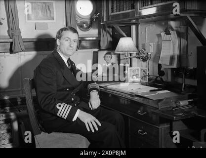 CAPTAIN (D) A K SCOTT-MONCRIEF, RN, AN SEINEM SCHREIBTISCH IN SEINER KABINE AN BORD DER HMS FAULKNOR. AM 10. FEBRUAR 1943 IN SCAPA FLOW. - , Stockfoto