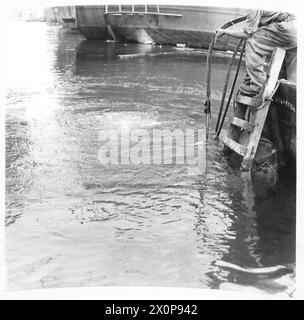 Fotografisches negativ, das einen Taucher der Royal Engineers zeigt, der unter Wasser absteigt, um Arbeiten durchzuführen, und zeigt militärische Tauchoperationen und technische Aufgaben. Stockfoto