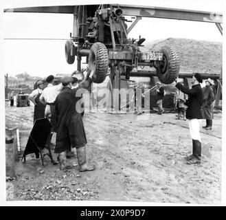 IM PROOFBEREICH: Die montierte Bofors-Pistole wird mit einem Kran gedreht, um sie auf einen LKW zu stellen. Fotografisches negativ, britische Armee Stockfoto