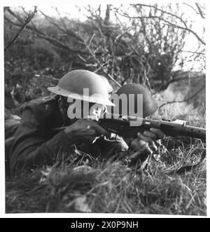 Fotografisches negativ, das einen Steinbruchzug der Hauswache in Aktion mit dem Platoon Commander zeigt, der eine Sten-Kanone der britischen Armee betreibt, und zeigt die Ausbildung und Feldoperationen. Stockfoto