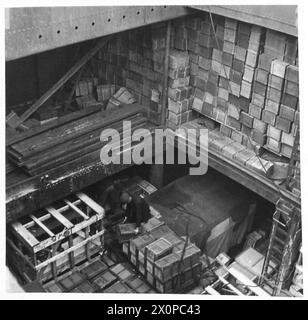Compo-Pakete werden physisch von Personal auf ein Militärschiff geladen, was den logistischen Prozess des Transports von Vorräten zeigt. Stockfoto