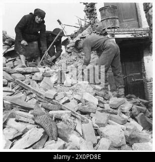 ITALIEN: DORF DER ACHTEN ARMYFRONT-LINIE - zwei britische Soldaten helfen einer Italienerin, einige der Trümmer aus ihrem Haus zu entfernen. Fotografisches negativ, britische Armee Stockfoto