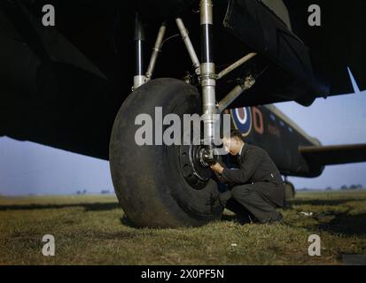 DIE ROYAL AIR FORCE IN GROSSBRITANNIEN, SEPTEMBER 1942 – Testen des Reifendrucks des Avro Lancaster R5540 von No 44 Squadron Conversion Flight bei Waddington, Lincolnshire Royal Air Force, Royal Air Force Regiment, Sqdn, 44 Stockfoto