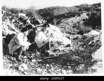 ALBANIEN: "HINTERZIMMER-JUNGS" AN DER VORDERSEITE - sie kauern sich hinter einem Felsen mit Blick auf eine Straße, die von den Deutschen benutzt wurde, und machen ihre Pläne. Fotografisches negativ, britische Armee Stockfoto